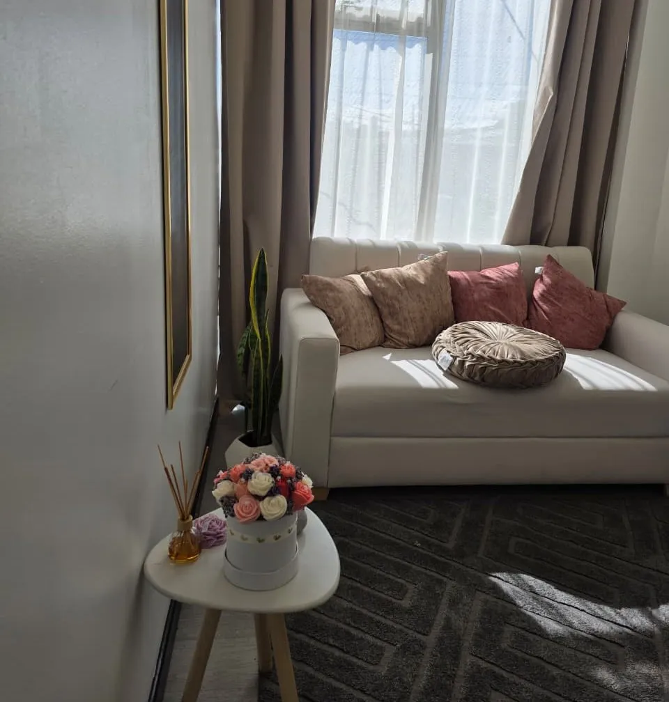 Sala del consultorio en Bogotá, con sofá claro, cojines y luz de ventana